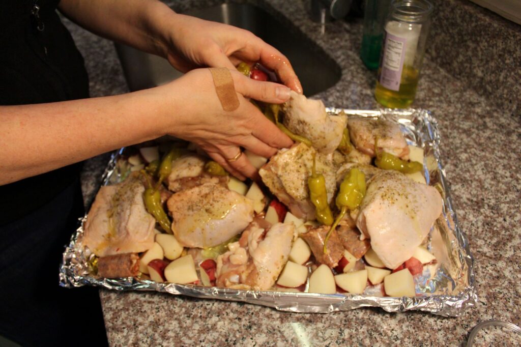 combine the chicken, sausages, and potatoes on the sheet pan